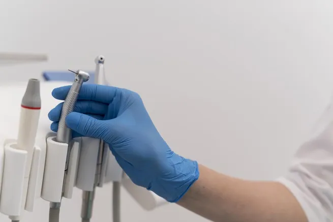 orthodontist with latex glove handling dental equipment 1 1